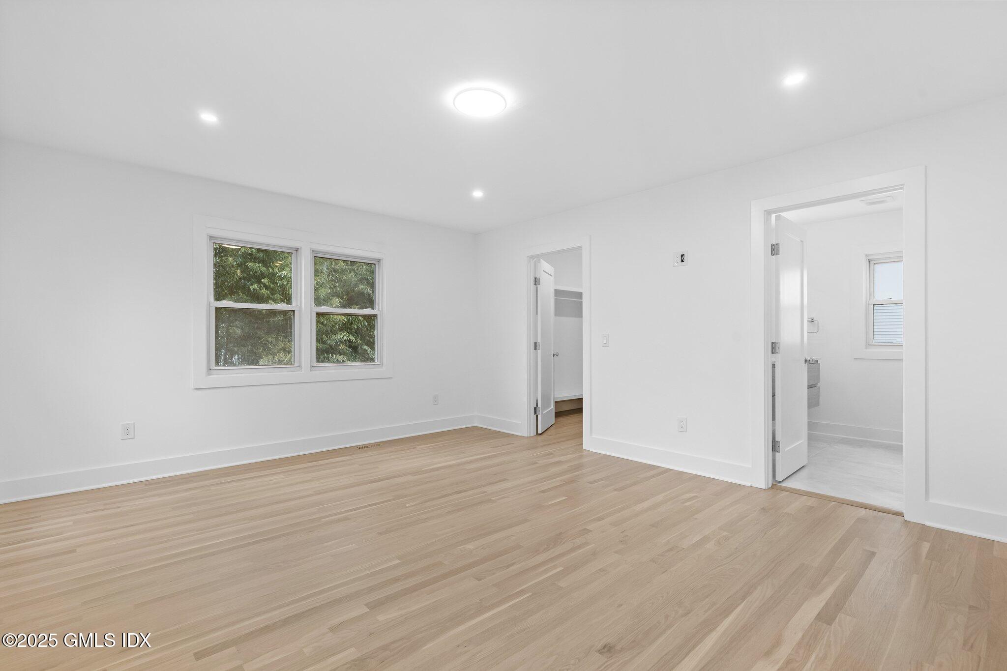 8 Pintail Lane Greenwich, CT 06830 - Photo 16 of 37 an empty room with wooden floor and windows