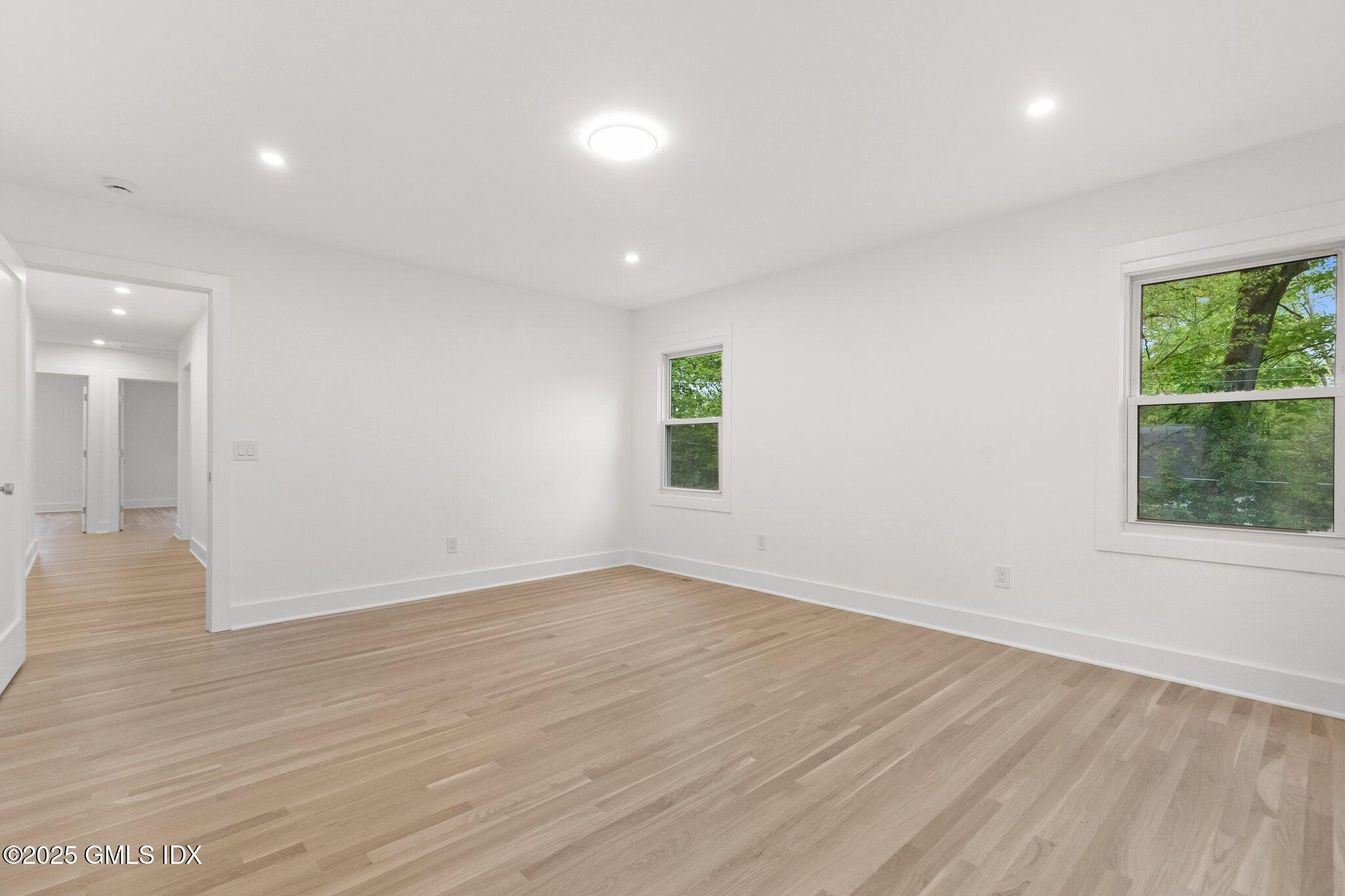 8 Pintail Lane Greenwich, CT 06830 - Photo 18 of 37 an empty room with wooden floor and windows