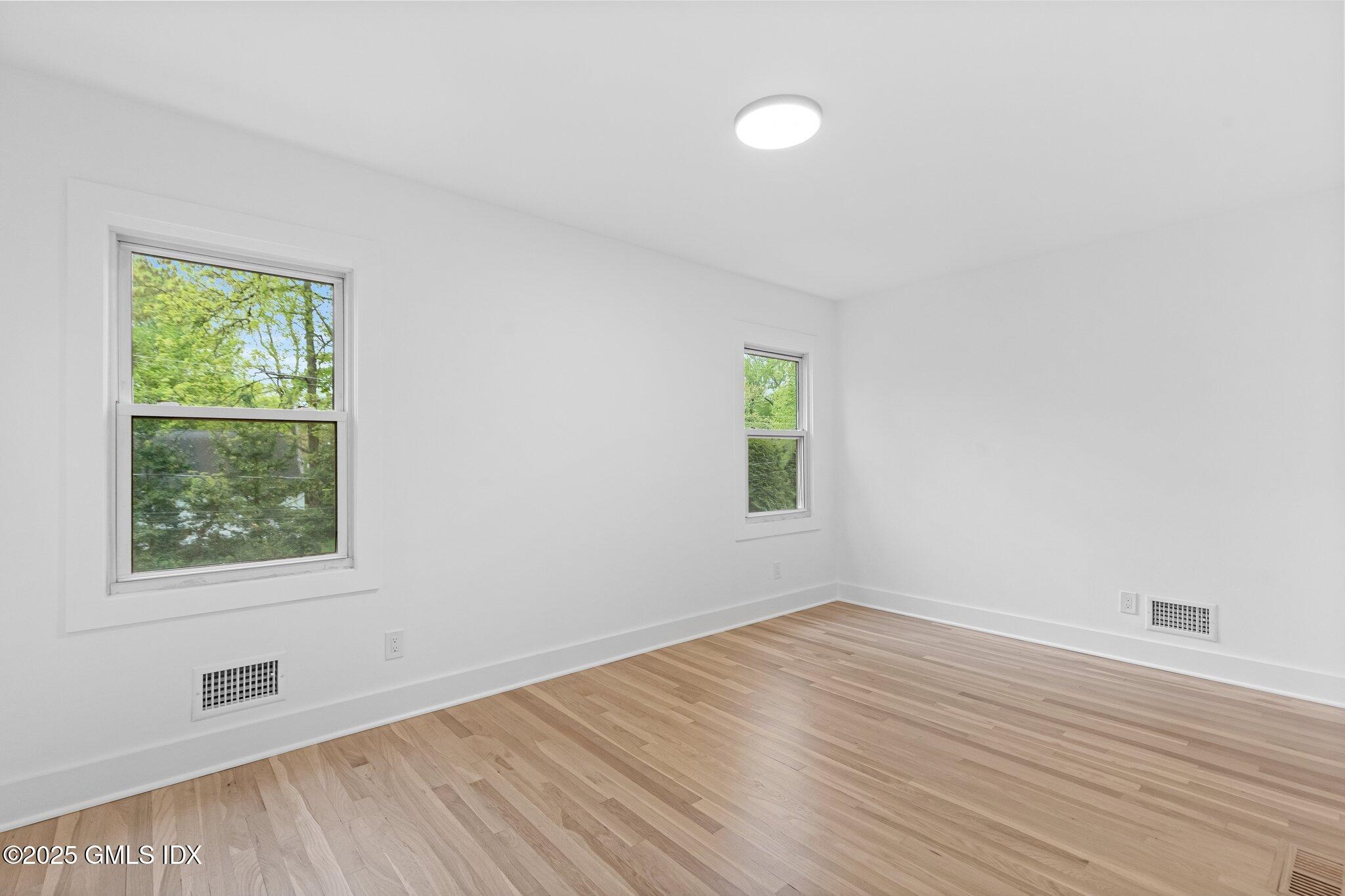 8 Pintail Lane Greenwich, CT 06830 - Photo 20 of 37 an empty room with wooden floor and windows