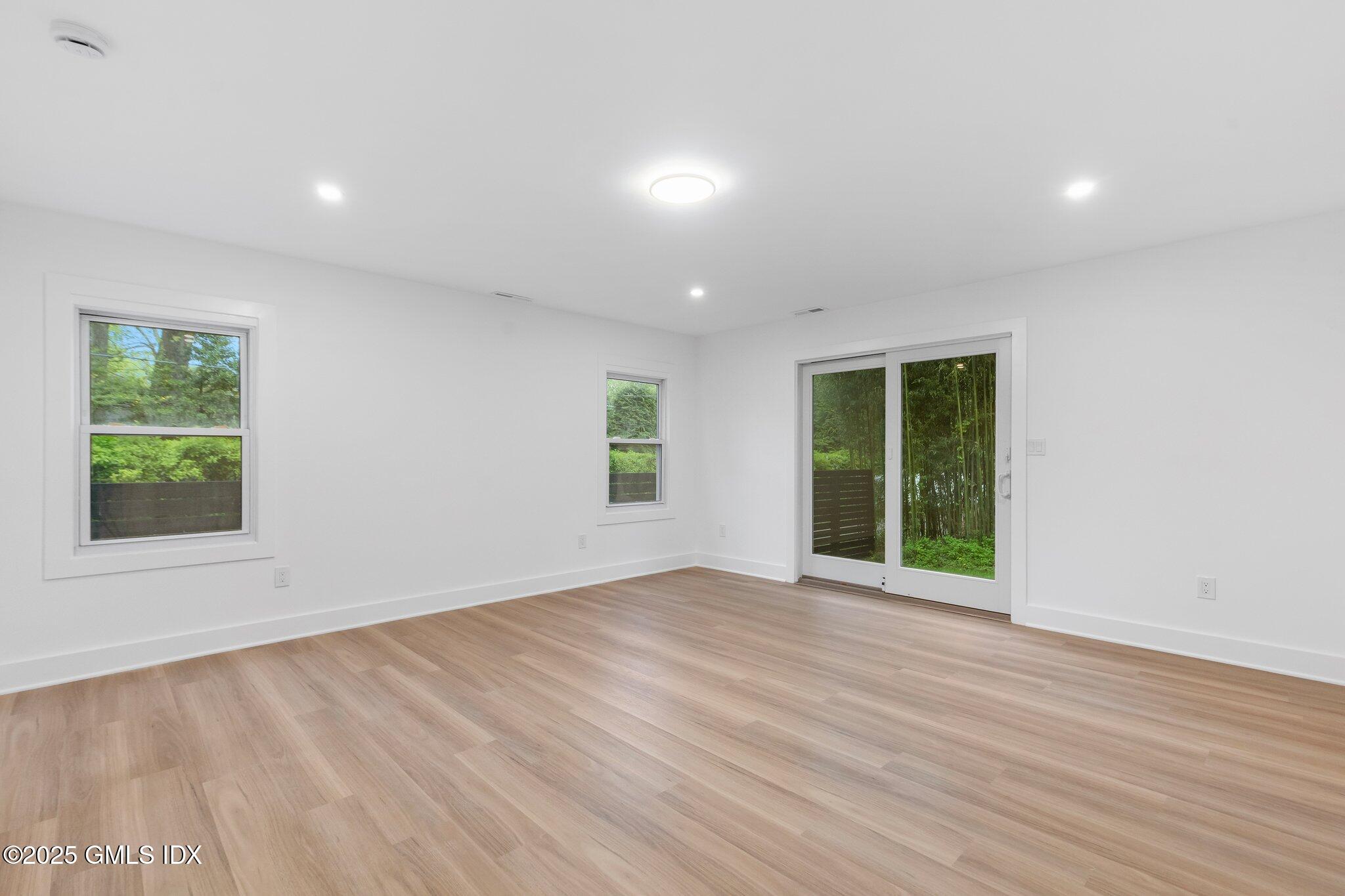 8 Pintail Lane Greenwich, CT 06830 - Photo 28 of 37 an empty room with wooden floor and windows