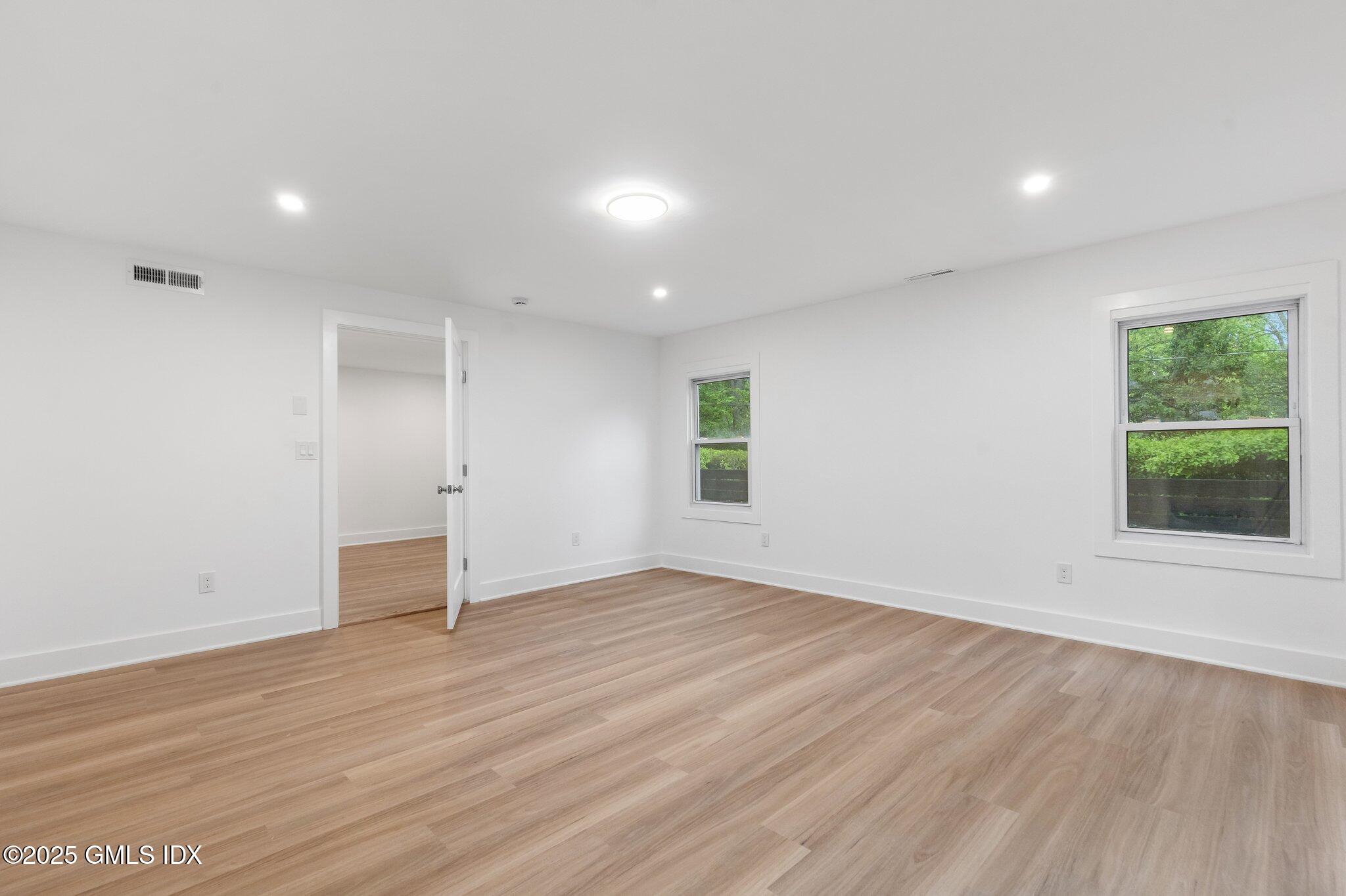 8 Pintail Lane Greenwich, CT 06830 - Photo 29 of 37 an empty room with wooden floor and windows