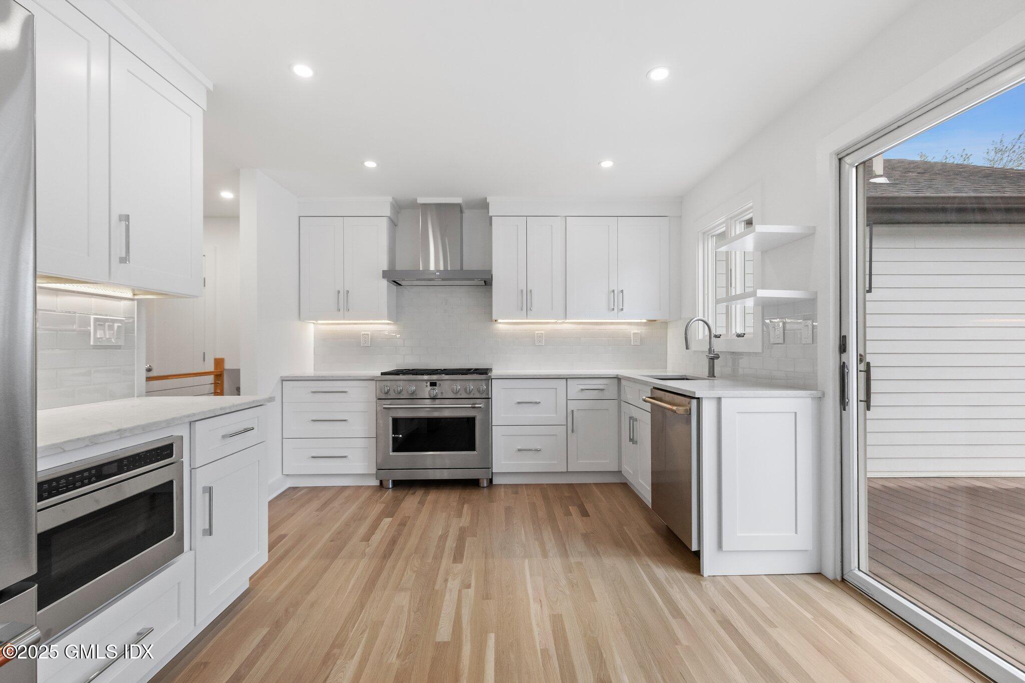 8 Pintail Lane Greenwich, CT 06830 - Photo 10 of 37 a kitchen with granite countertop a stove top oven and cabinets