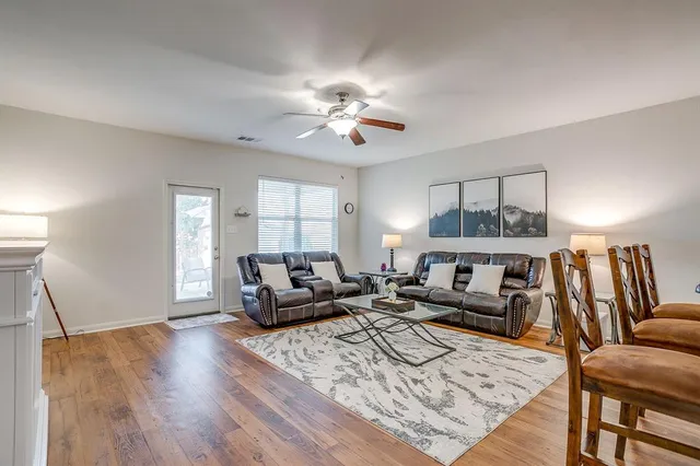 a living room with furniture and a wooden floor