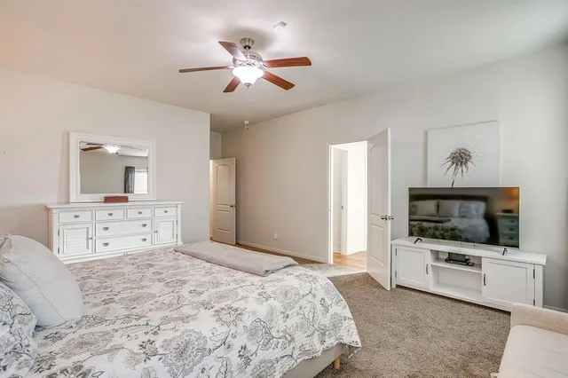 a spacious bedroom with a bed and a flat screen tv