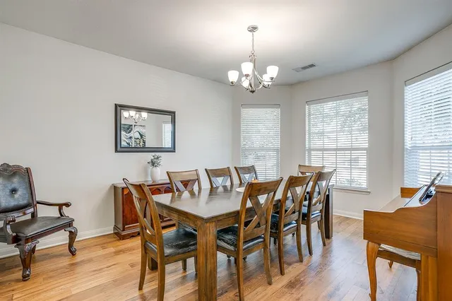 a view of a dining room with furniture a chandelier and wooden floor
