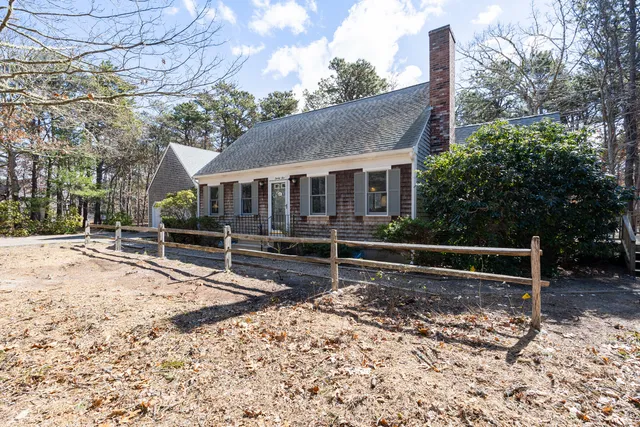 a view of a house with a wooden fence