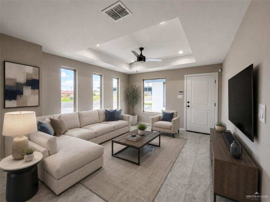 707 Palmer Road, Unit 3 Mission, TX 78573 - Photo 5 of 8 Spacious living area featuring light-toned tile flooring, a tray ceiling with recessed lighting, and a contemporary ceiling fan