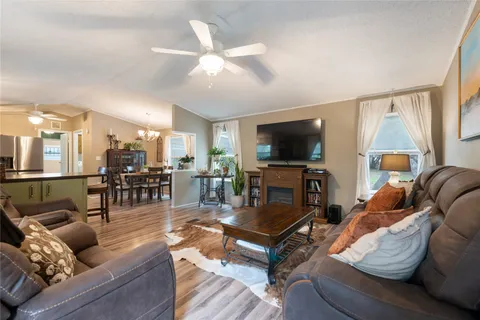 a kitchen with stainless steel appliances granite countertop a sink dishwasher a refrigerator with wooden cabinets and floor