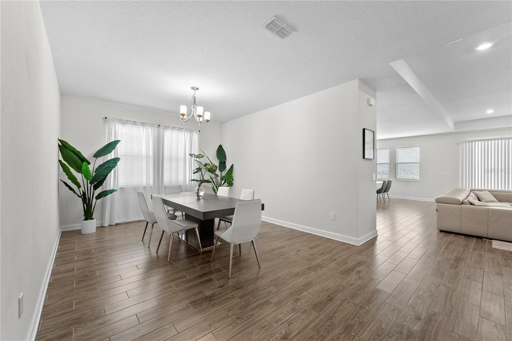2926 Wordsmith Road Kissimmee, FL 34746 - Photo 12 of 42 a view of a dining room with furniture and wooden floor