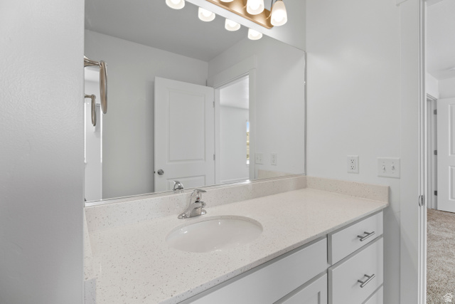 1271 West 500 South Logan, UT 84321 - Photo 16 of 26 Modern bathroom vanity featuring a light speckled countertop, integrated sink, and brushed nickel faucet
