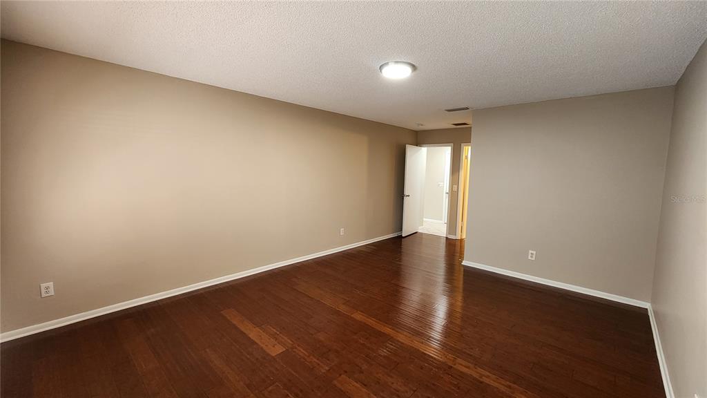 14921 Old Pointe Road Tampa, FL 33613 - Photo 12 of 32 a view of an empty room with wooden floor and window