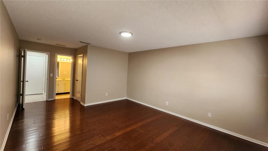 14921 Old Pointe Road Tampa, FL 33613 - Photo 13 of 32 a view of an empty room with wooden floor and a window