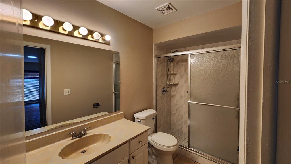 14921 Old Pointe Road Tampa, FL 33613 - Photo 17 of 32 a bathroom with a sink vanity granite toilet and a shower