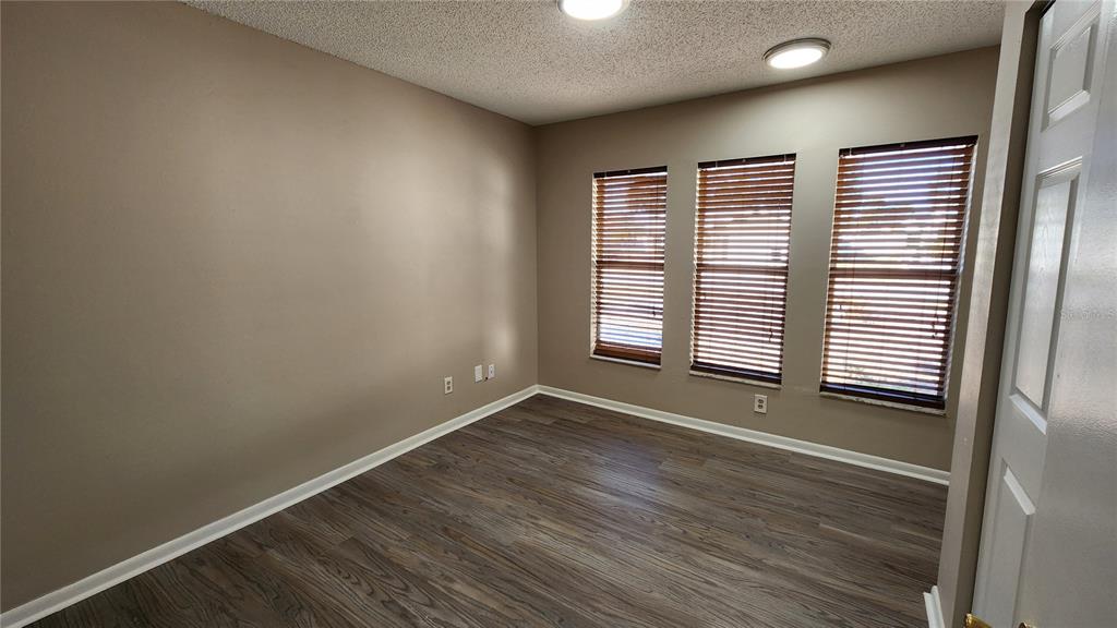 14921 Old Pointe Road Tampa, FL 33613 - Photo 18 of 32 an empty room with wooden floor and windows