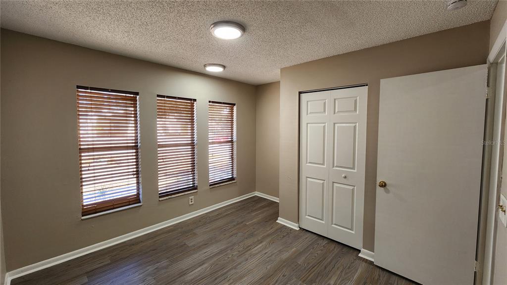 14921 Old Pointe Road Tampa, FL 33613 - Photo 19 of 32 an empty room with wooden floor and windows