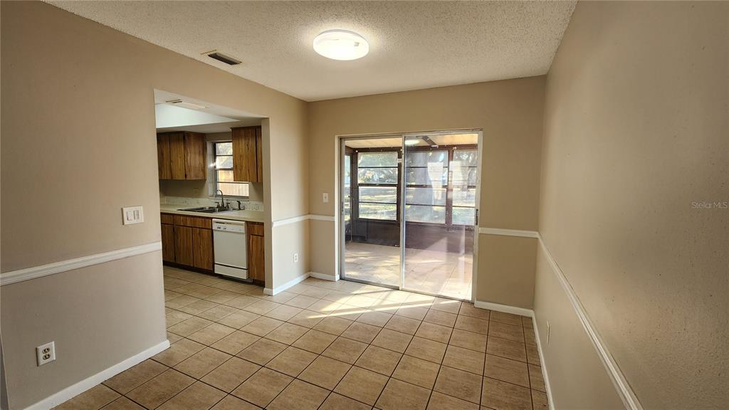 14921 Old Pointe Road Tampa, FL 33613 - Photo 8 of 32 a view of a kitchen with a sink and dishwasher a refrigerator with white cabinets