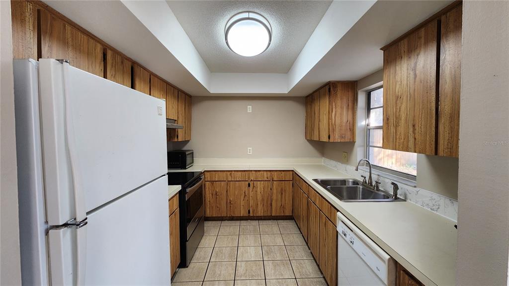14921 Old Pointe Road Tampa, FL 33613 - Photo 9 of 32 a kitchen with a sink cabinets and stainless steel appliances