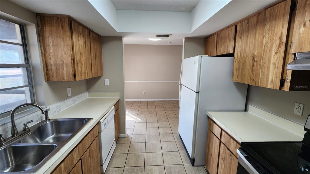 14921 Old Pointe Road Tampa, FL 33613 - Photo 10 of 32 a kitchen with stainless steel appliances a refrigerator sink and stove