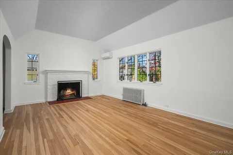 a view of an empty room with a fireplace and a window