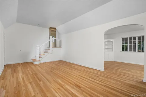 a view of empty room with wooden floor and fireplace