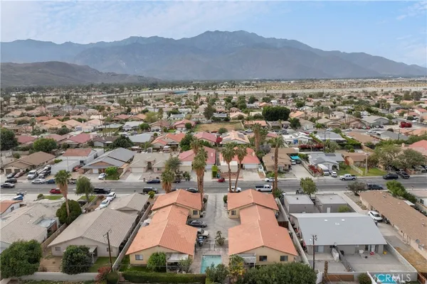 an aerial view of residential houses with outdoor space and trees