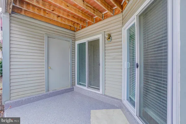 a view of a porch with a door and wooden floor