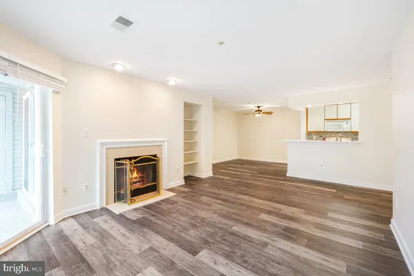 a view of empty room with a fireplace and wooden floor