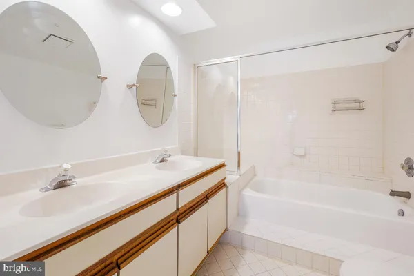 a bathroom with a tub sink and mirror