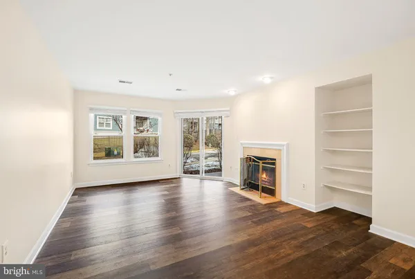 a view of an empty room with a fireplace and a window