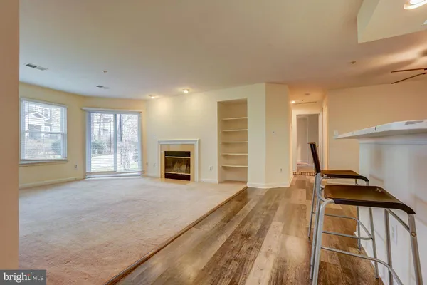 a view of an empty room with a fireplace and a window