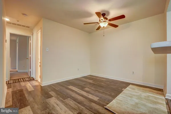 a view of a room with wooden floor and a ceiling fan