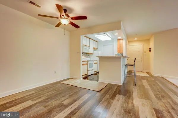 a view of a kitchen with a wooden floor and a ceiling fan