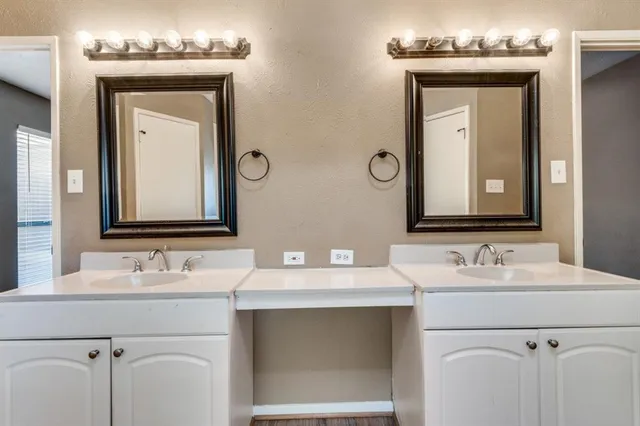 a bathroom with a double vanity sink and a mirror