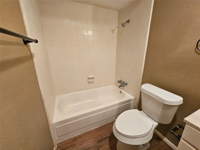 a white toilet sitting next to a bath tub