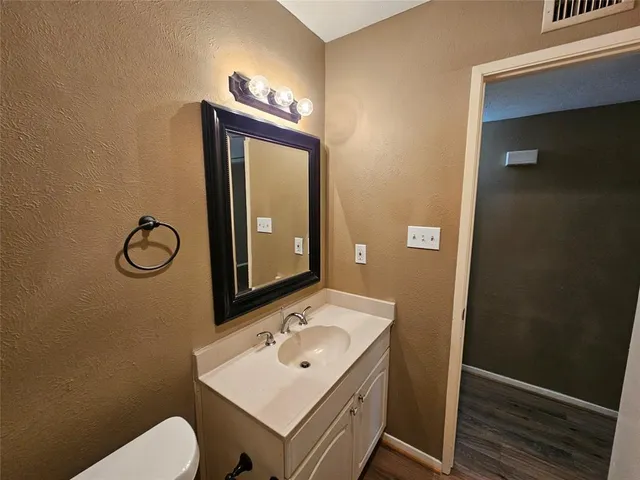 a bathroom with a toilet sink vanity and mirror