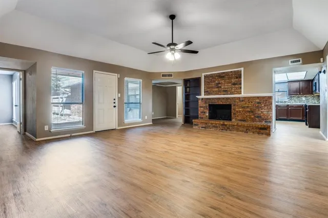 a view of a livingroom with a fireplace a chandelier and wooden floor