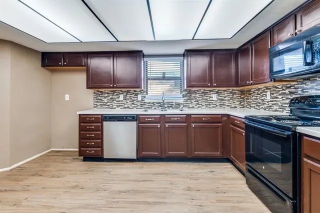 a kitchen with stainless steel appliances granite countertop a stove a sink and a microwave