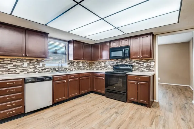 a kitchen with granite countertop wooden cabinets stainless steel appliances and a window