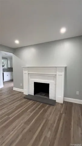 an empty room with wooden floor and fireplace