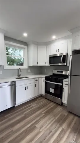 a kitchen with stainless steel appliances kitchen island granite countertop a stove a sink and a microwave