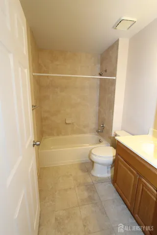 a bathroom with a bathtub shower sink vanity and toilet