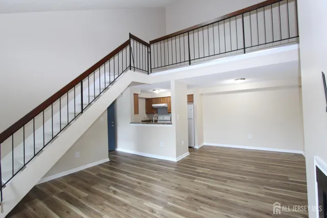 a view of staircase with wooden floor and white walls