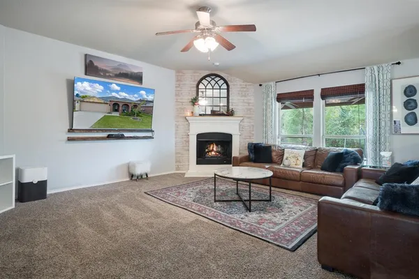 a living room with furniture a fireplace and a flat screen tv
