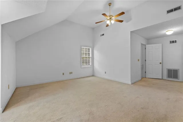 an empty room with closet and a ceiling fan