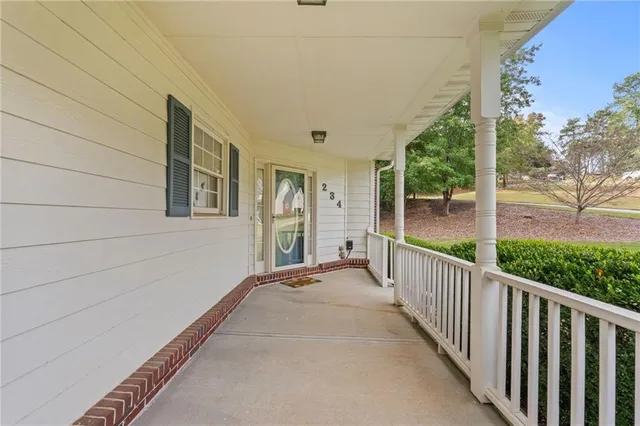 a view of a porch with wooden floor and fence
