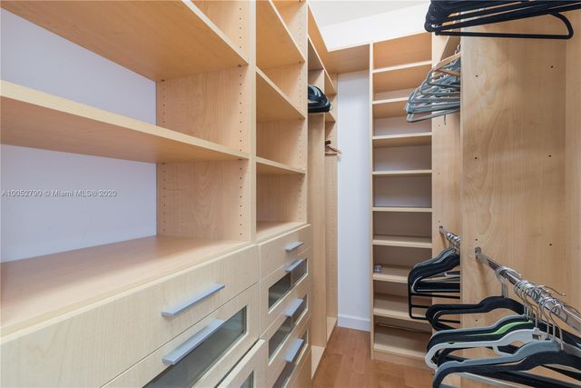 a view of walk in closet with clothes and shoes