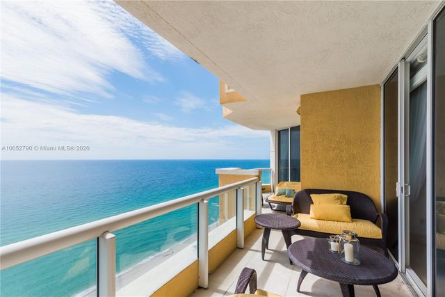 a balcony with table and chairs