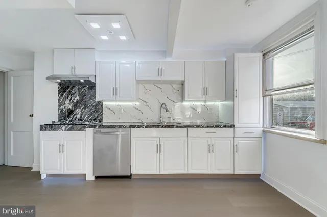 a kitchen with kitchen island granite countertop white cabinets and window
