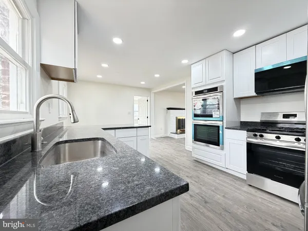 a kitchen with granite countertop a sink a refrigerator and window