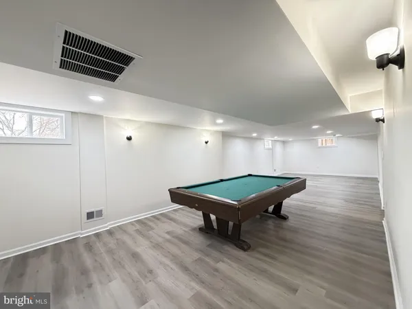 a room with wooden floor and pool table